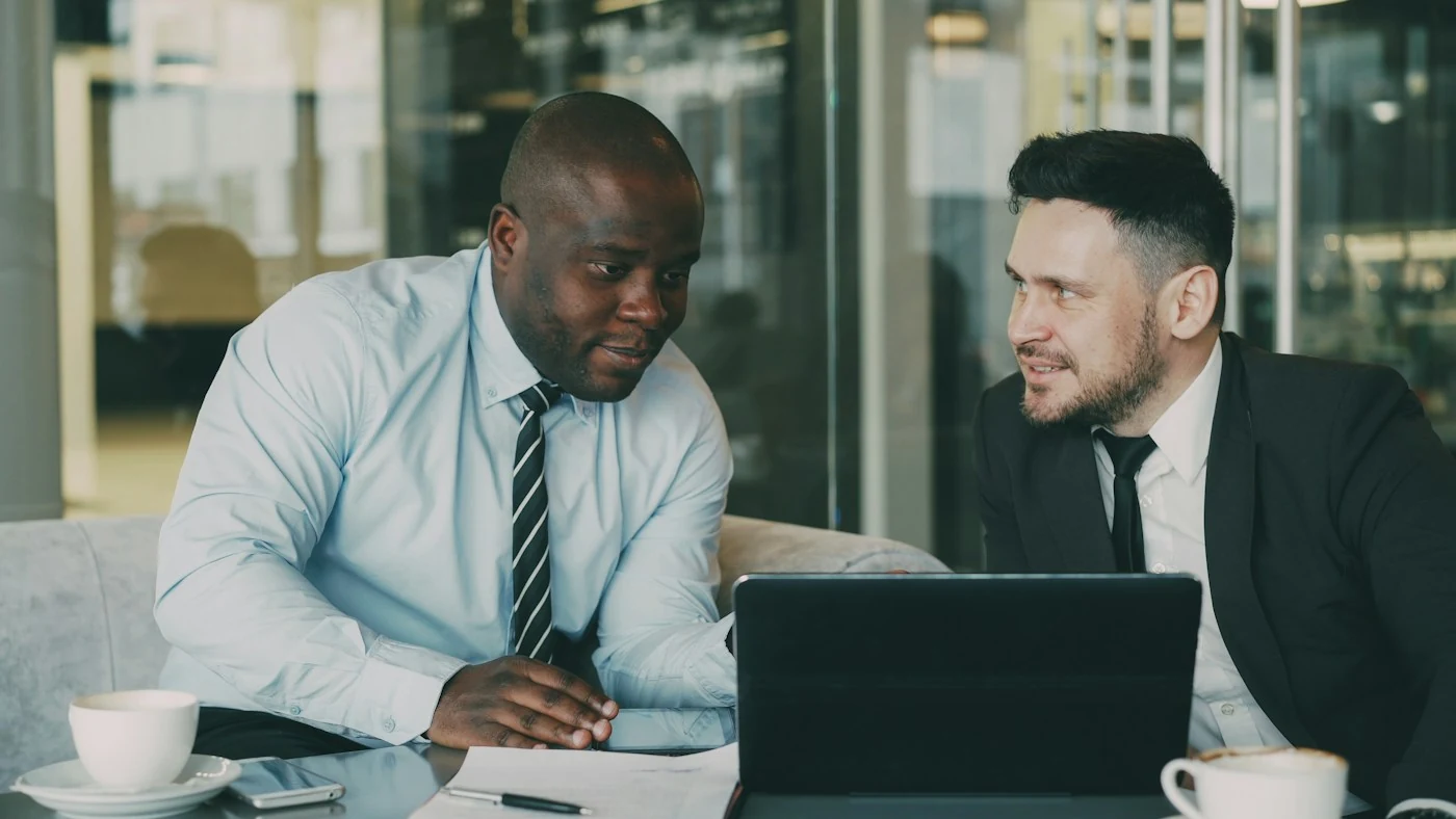 Two colleagues discussing a project at a laptop